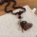 Détail macro du pendentif cœur en peluche léopard avec finitions en cuir et pompon - Collier-Marron-Croix