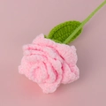 Close-up detail of a handmade pink crochet rose with green leaf on a soft pink background - Pointed Rose Branch - Pink