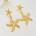 Minimalist double layer golden starfish drop earrings on a clean white textured surface - Double Layer Starfish Drop Earrings / Medium KC Gold (N-444)