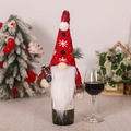 Christmas gnome wine bottle cover with red knit hat, white beard and mini vintage lantern - Holding Kerosene Lamp Style