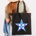 Black canvas tote bag with white star and Greek Evil Eye print carried by a model - Design J-Five Star Eye-Black