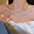 Detail of white camellia pendant necklace with pearls and gold beads on model neck - Flower Pearl String Style (X1376) / Gold/White Camellia