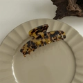 Close-up of amber leopard print acetate claw clip on a minimalist ceramic display plate - Round Top Rib Claw