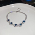 Macro detail of silver tennis bracelet with square blue gemstones and halo zircon settings - Blue Square (HB4470)