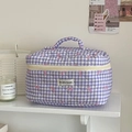 Quilted cotton checkered makeup bag with bow detail and handle on a shelf - Makeup Bag / Purple