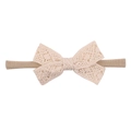 Vue détaillée du nœud en dentelle beige et du bandeau élastique pour bébés filles - Beige