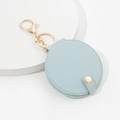 Light blue round PU leather keychain mirror with gold lobster clasp on white stand - Blue