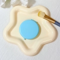 Portable round folding vanity mirror in light blue next to a cream star-shaped tray - 65mm / Sky Blue