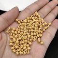 Golden flower petal spacer beads for DIY jewelry making held in hand for scale - 05 (4.5mm Petal Hollow Bead)