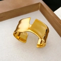 Detailed macro of gold irregular wavy cuff bracelet on soft neutral fabric texture - Gold Wide Irregular