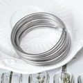 Bracciale a molla multistrato argento su un piatto in ceramica con decoro a rilievo - Argento
