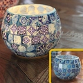 Blue and white mosaic glass candle holder with glowing warm light on wooden table - Blue and White Porcelain