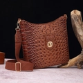 Detail of brown crocodile pattern shoulder bag with golden hardware and wide strap - Chocolate