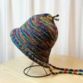 Knitted bucket hat with colorful stripes and decorative tie straps on a stand - Rainbow Colorful Hat
