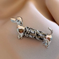Macro shot of silver metal dachshund brooch with colorful braided rope detail on satin - 82# Silver - Dog