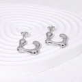 Unregelmäßige Ohrstecker aus silbernem Edelstahl auf einem gewellten Präsentieständer - Stahlfarbe