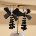 Detalle de pendientes con lazo de gasa negra con diamantes de imitación y borlas de perla - Negro