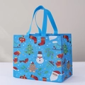 Blue Christmas non-woven gift bag featuring Santa, snowman, and holiday prints - Christmas Style 11