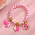 Bracelet de perles roses avec breloques ruban de sensibilisation sur fond rose - Bracelet en Perles Artificielles Dorées (8726)