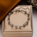 Bracciale a catena argentata con maglie a U e chiusura a sfera su un elegante portagioie - Stile Argentato (996)