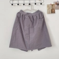 Detalle del delantal de algodón gris púrpura con bolsillos grandes y cintura plisada - Gris claro