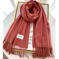 Primer plano de bufanda de punto gruesa color ladrillo con flecos y etiqueta de la marca - Rojo Pasta de Frijol