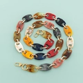 Detail of colorful acrylic resin chain strap with gold metal hooks on a mint green background - Large Pig Nose Mixed with Gold
