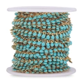 Golden stainless steel chain with vibrant blue enamel teardrop beads on white spool - Blue