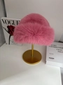 Winter faux fur bucket hat in vibrant rose pink with fluffy texture on a gold stand - Peach Pink