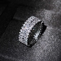 Anello d'argento con zirconi quadrati e rotondi su sfondo di tessuto scuro strutturato - US 6 / Oro Bianco