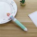 Bolígrafo multicolor verde claro con adorno de cerdito rosa en mesa de madera - Bolígrafo verde cerdo corona