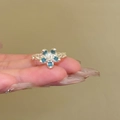 Dettaglio di un anello intrecciato argento con fiore blu a cinque petali e diamante - Stile Aperto Fiore Blu a Cinque Petali (1#)