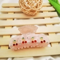 Pink translucent cherry hair claw clip with rhinestones on a wooden background - Pink