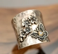 Macro view of vintage wide ring with embossed flowers and blue crystal butterfly - Flower Butterfly with Blue Stone (KYRA01486)