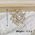 Golden butterfly wreath brooch with rhinestones and pearls on beige knit background - KC Gold Three Butterflies