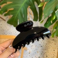 Close-up of a large glossy black acrylic hair claw clip held in hand for thick hair - 10cm Yuanbao Claw / Glossy Black