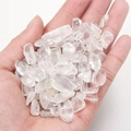 Hand holding polished natural clear quartz crystal stone chips for healing and decor - Clear Quartz Premium (100g)