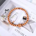 Nordic magnetic curtain tieback with light brown wooden beads on magazine background - Tan