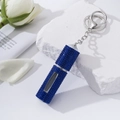 Macro view of blue rhinestone refillable perfume bottle keychain with clear window - Royal Blue