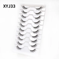 Detailed 45-degree angle of 10 pairs of natural cat-eye thick false eyelashes on white tray - Curled Voluminous Style (XYJ33) / 10 Pairs Set