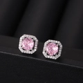 Macro shot of pink zircon earrings featuring a round center stone and a halo of white gems - Pink