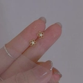 Elegant gold flower stud earrings with white zircon center held in hand to show size - Gold Rhinestone Flower