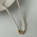 Elegante Perlenkette mit goldenem Herzanhänger und Perle auf weißem Hintergrund - Weiße Perlenimitation mit Herzanhänger / Weiß