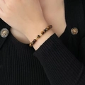 Tiger eye stone bead bracelet with gold metal spacers worn on woman's wrist - Brown Yellow Tiger Eye Gold Spacer (MY36905)