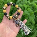 Dettaglio del cinturino in perline di silicone leopardato con ciondolo a testa di toro - Leopardo Marrone Giallastro
