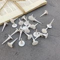 White plastic birthday cake topper bases scattered on a grey textured surface - Small Cake Tray Base