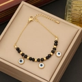 Gold evil eye bracelet with black crystal beads and three blue eye charms on jewelry box - Evil Eye Black Beaded Bracelet