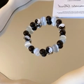 Close-up of retro black and white beaded bracelet with yin yang charms on a mirror - Black-White-Tai Chi