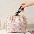 Putting hand cream into a quilted drawstring bag with pink roses and bows - Pink Bowknot