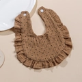 Detail of ruffled khaki cotton baby bib with black polka dots and snap button closure - Coffee Polka Dots